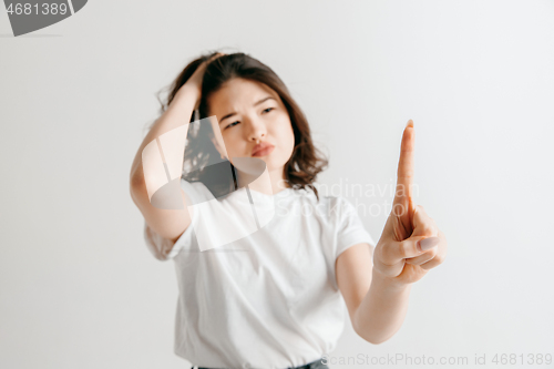 Image of Woman\'s hand with finger on gray background