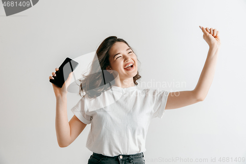 Image of Portrait of a confident casual asian girl showing blank screen of mobile phone