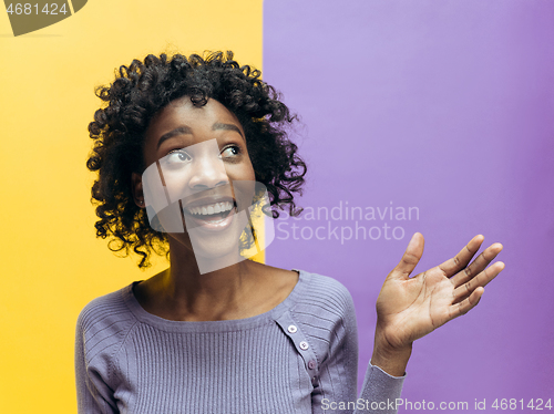 Image of The happy african woman standing and smiling against gray background.