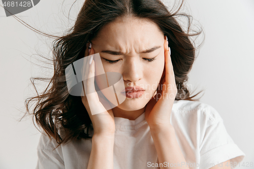 Image of Woman having headache. Isolated over gray background.