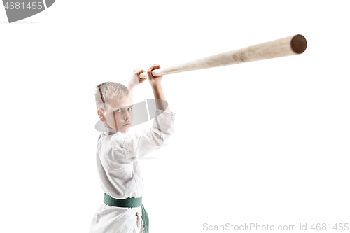 Image of Teen boy fighting with wooden sword at Aikido training in martial arts school