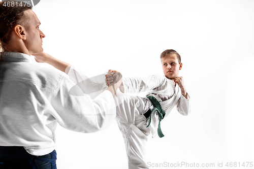 Image of Man and teen boy fighting at aikido training in martial arts school