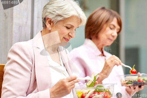 Image of senior women eating takeaway food on city street