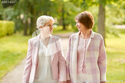 Image of senior women or friends walking along summer park