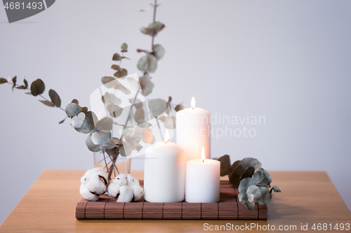 Image of candles and branches of eucalyptus on table