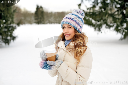 Image of happy woman drinking coffee outdoors in winter