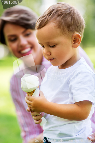 Image of little boy eating ice cream with mother in summer