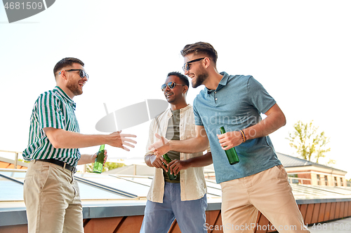 Image of happy male friends with beer meeting on rooftop