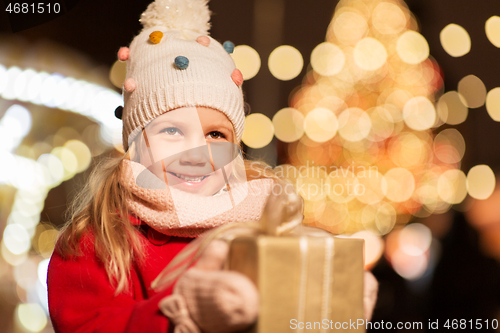 Image of happy girl with gift box at christmas market