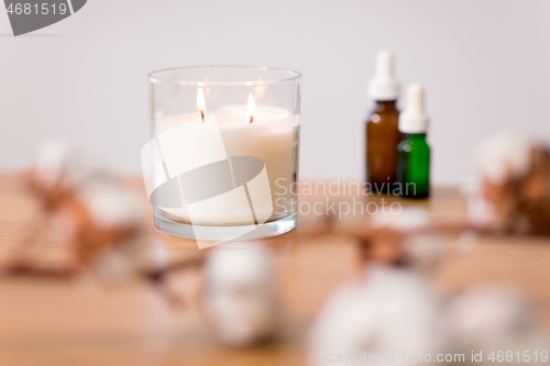 Image of burning home fragrance candle in glass holder