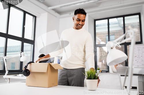 Image of happy male office worker with personal stuff