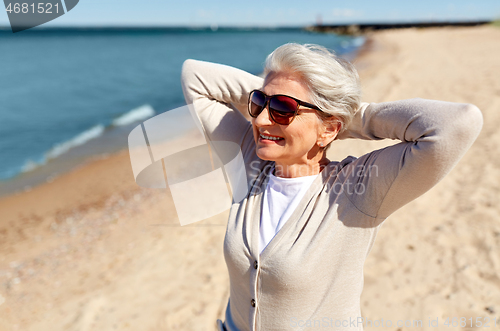 Image of portrait of senior woman in sunglasses on beach