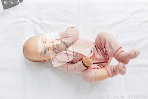 Image of sweet baby girl lying on white blanket