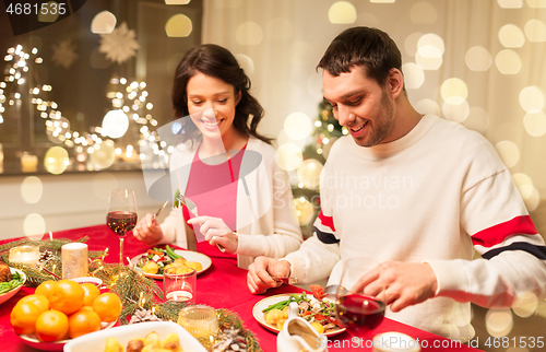 Image of happy couple eating at christmas dinner