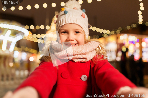 Image of little girl taking selfie at christmas market