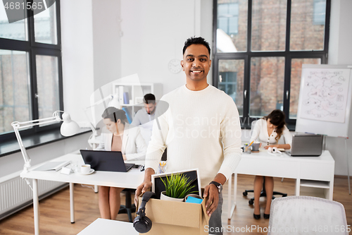 Image of happy male office worker with personal stuff