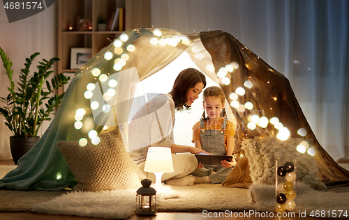 Image of family with tablet pc in kids tent at home