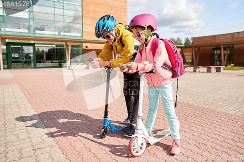 Image of school children with smartphones and scooters