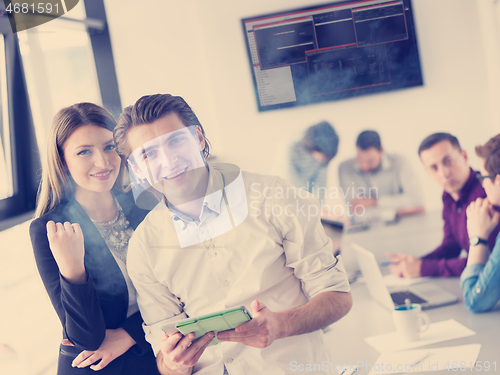 Image of Two Business People Working With Tablet in office