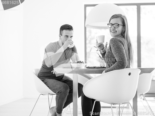 Image of couple enjoying morning coffee and strawberries