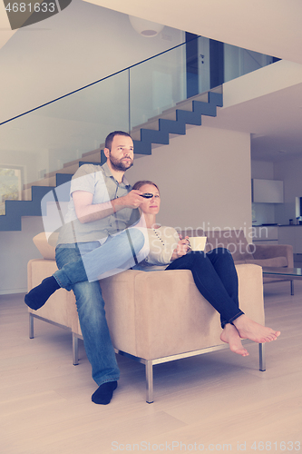 Image of romantic couple on the sofa watching television