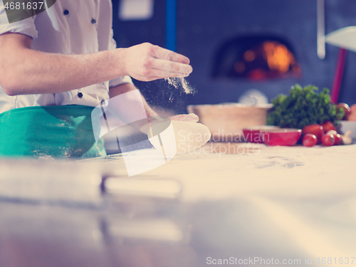 Image of chef hands preparing dough for pizza