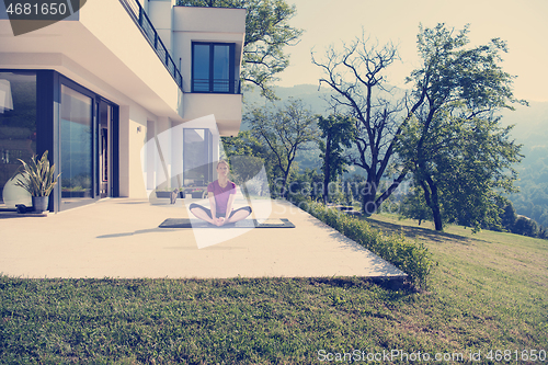 Image of handsome woman doing morning yoga exercises