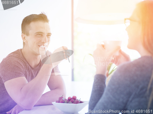 Image of couple enjoying morning coffee and strawberries