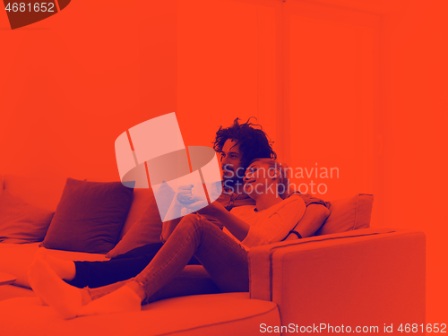 Image of Young couple on the sofa watching television