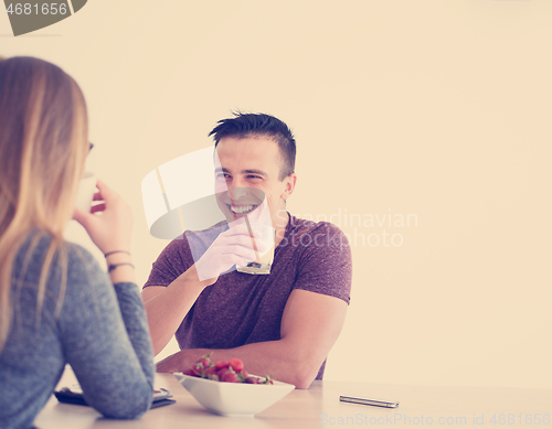 Image of couple enjoying morning coffee and strawberries