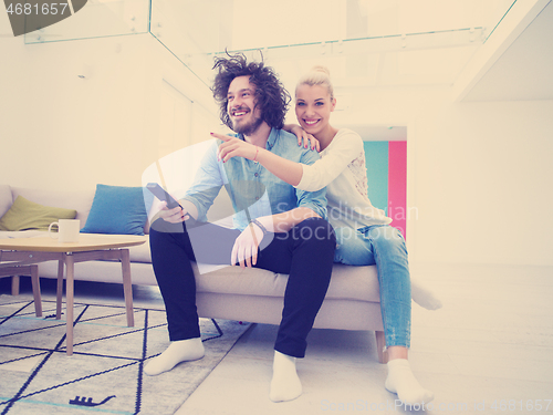 Image of Young couple on the sofa watching television