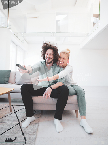 Image of Young couple on the sofa watching television
