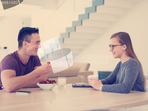 Image of couple enjoying morning coffee and strawberries