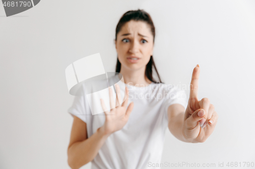 Image of Woman\'s hand with finger on gray background
