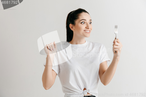 Image of Young fun crazy brunette housewife with fork isolated on white background