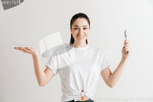 Image of Young fun crazy brunette housewife with fork isolated on white background