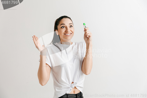 Image of Smiling young woman looking on pregnancy test