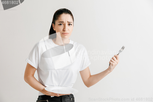 Image of Young fun crazy brunette housewife with fork isolated on white background