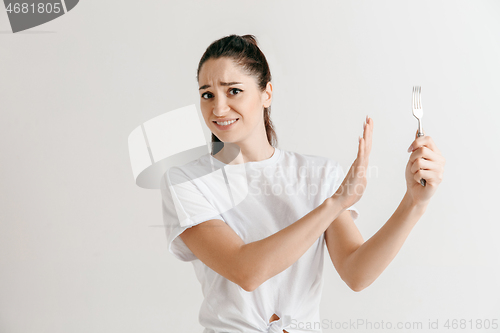 Image of Young fun crazy brunette housewife with fork isolated on white background