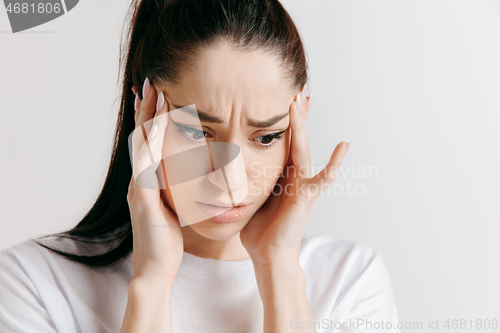 Image of Woman having headache. Isolated over gray background.