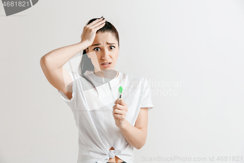 Image of Young woman looking on pregnancy test