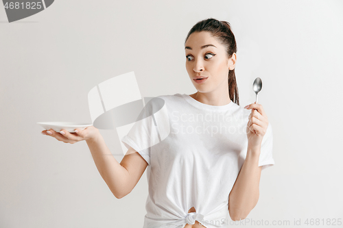 Image of Young fun crazy brunette housewife with spoon isolated on white background