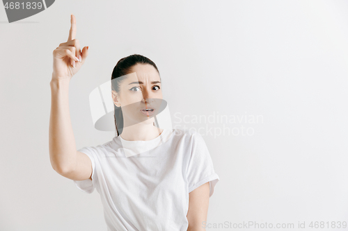 Image of The happy woman standing and smiling against gray background.