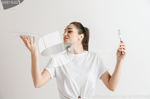 Image of Young fun crazy brunette housewife with fork isolated on white background