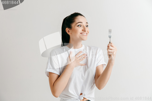 Image of Young fun crazy brunette housewife with fork isolated on white background