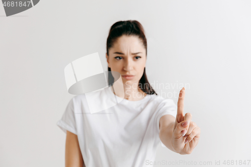 Image of Woman\'s hand with finger on gray background