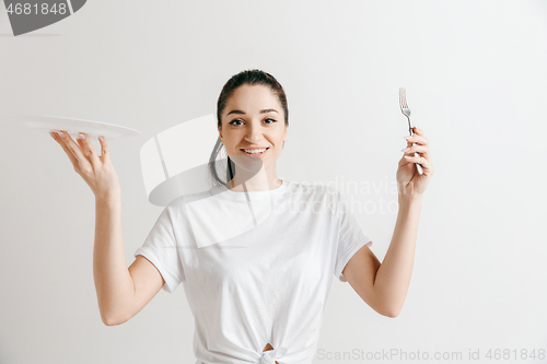 Image of Young fun crazy brunette housewife with fork isolated on white background