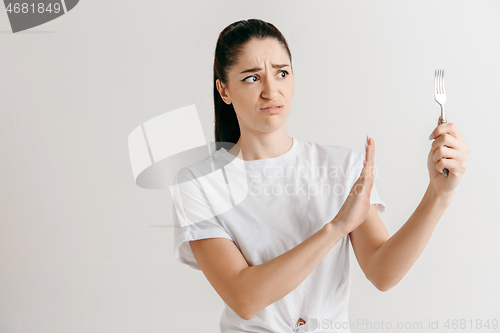 Image of Young fun crazy brunette housewife with fork isolated on white background