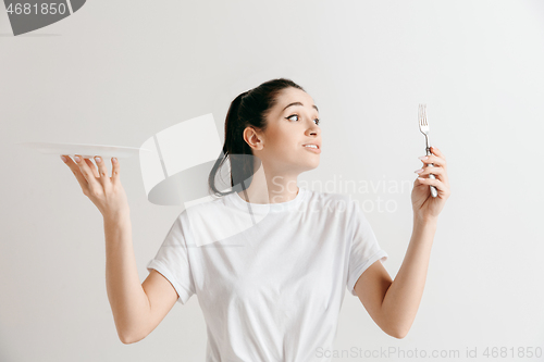 Image of Young fun crazy brunette housewife with fork isolated on white background