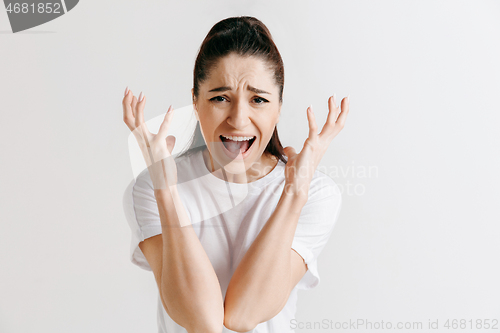 Image of The young emotional angry woman screaming on gray studio background